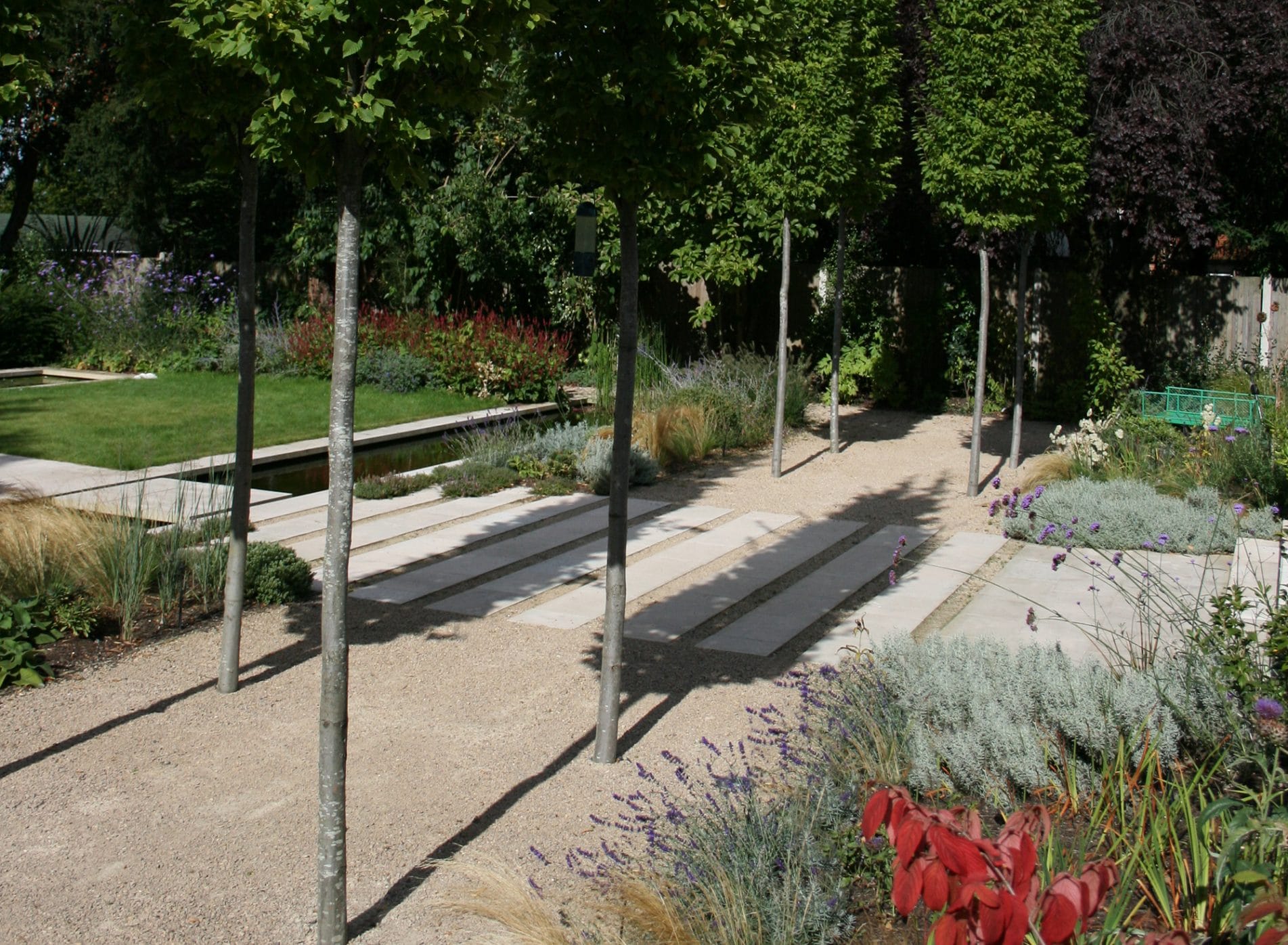 A tree lined path in the arts and crafts themed garden