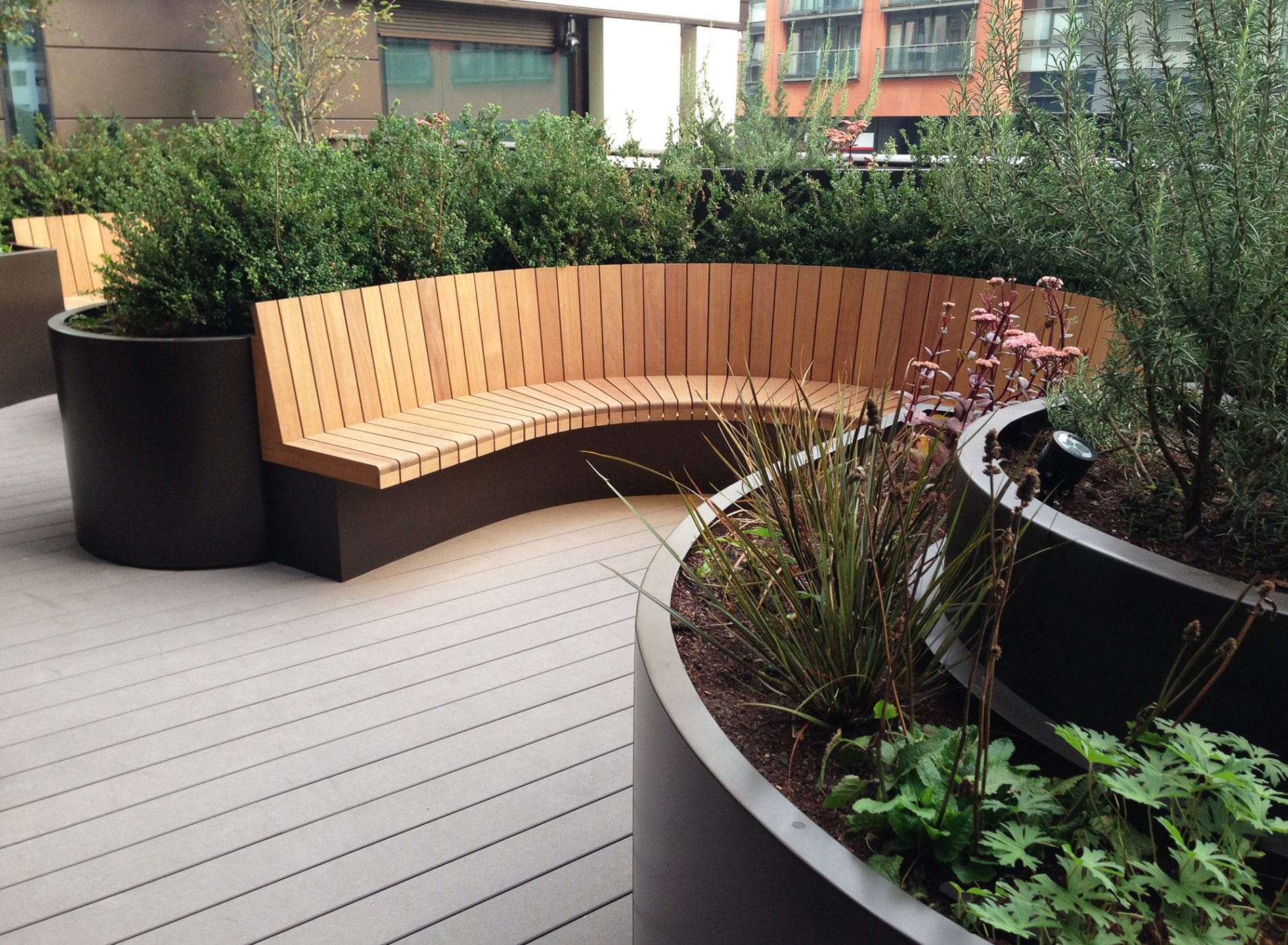 Curved seating and planters with evergreen hedges