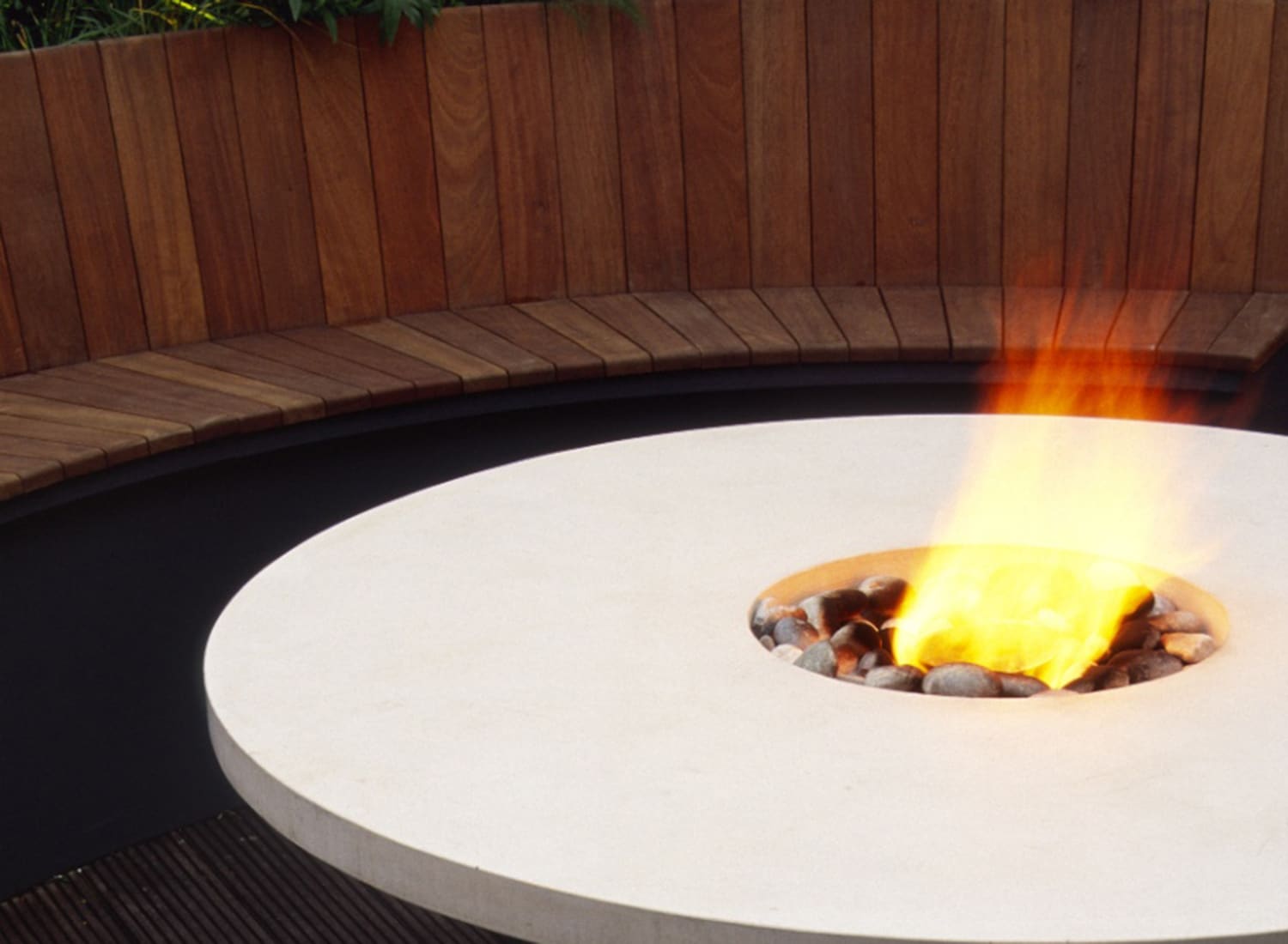 Curved seating and bespoke table with central flambeau for a Knightsbridge Roof Terrace
