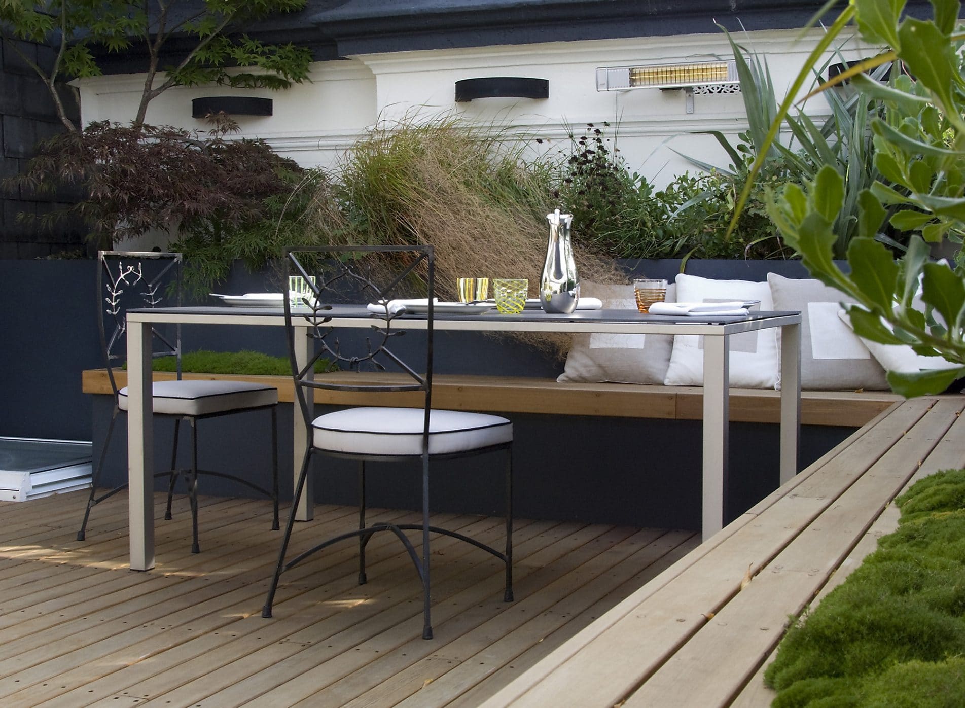 Outdoor dining area with bench seating table and delicate metal chairs