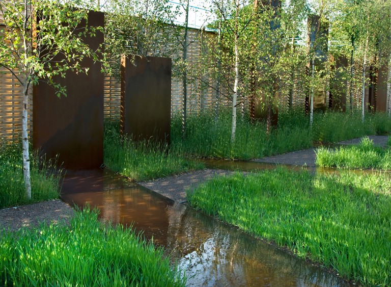 Water features between the fields of wheat leading towards the corten monoliths