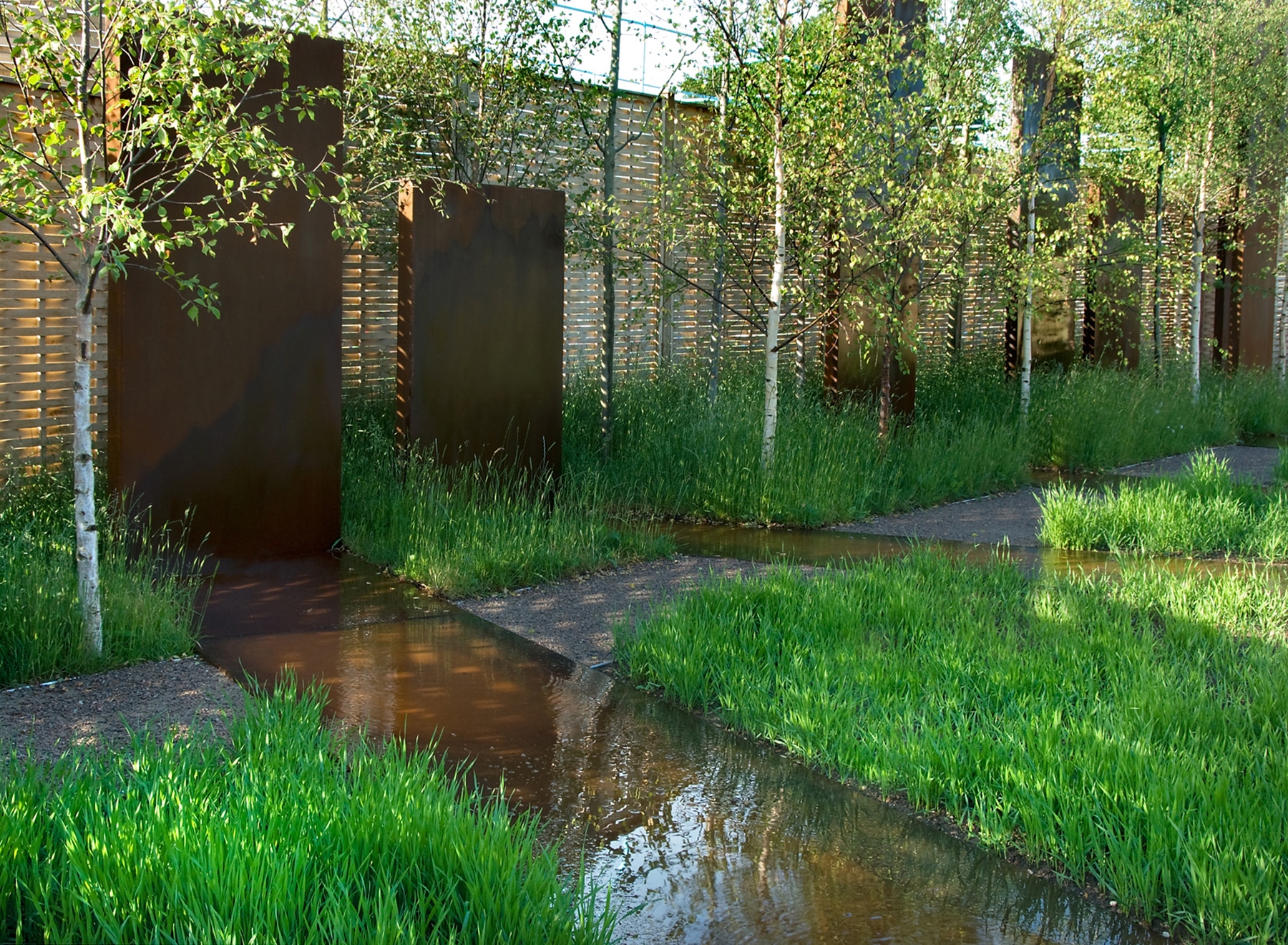Water features between the fields of wheat leading towards the corten monoliths
