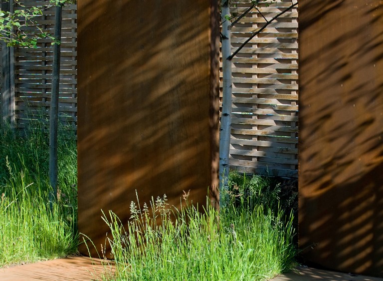 Corten monoliths with fencing in between in the 'Urban Greening' garden