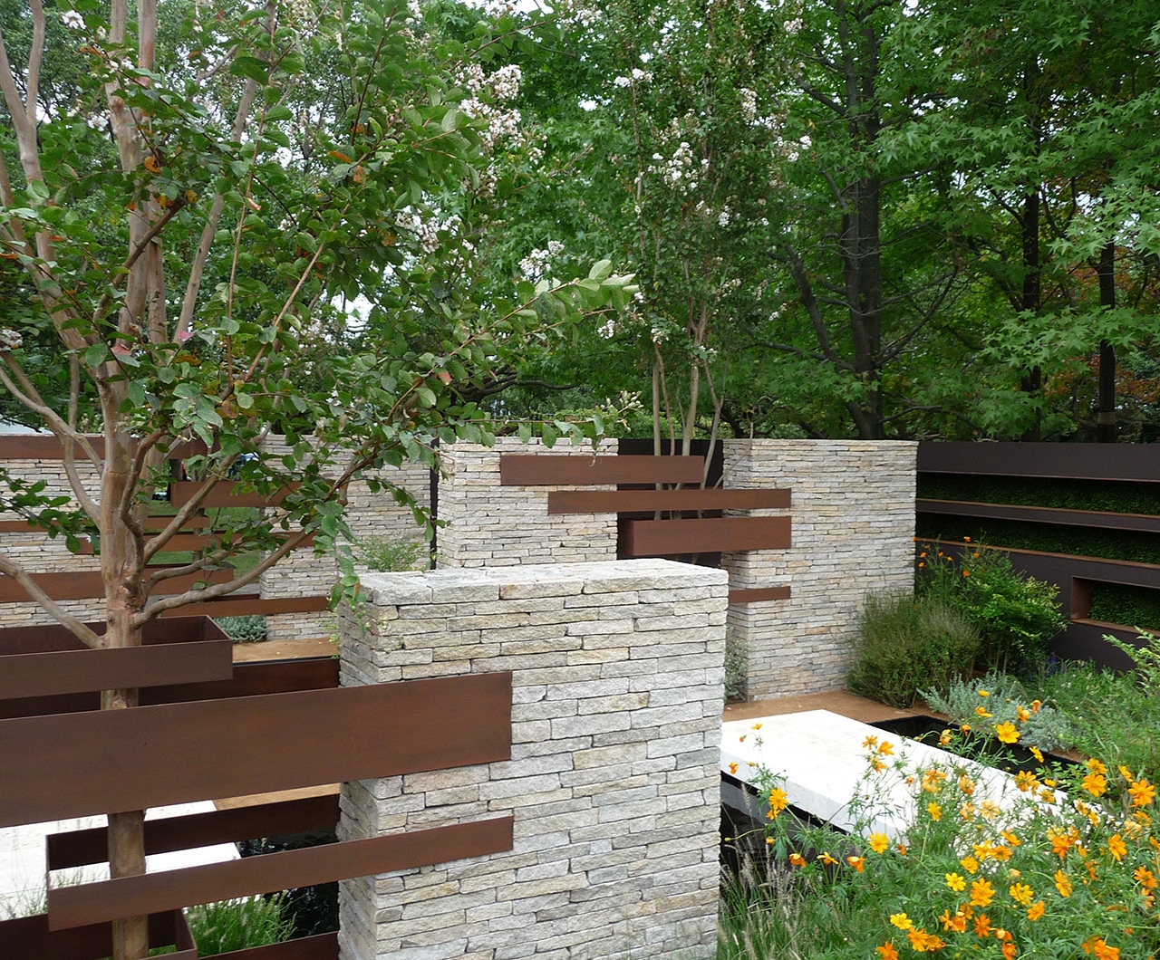 Linear stone and metal sculptures embracing the trees in the Gardening World Cup 2010 garden