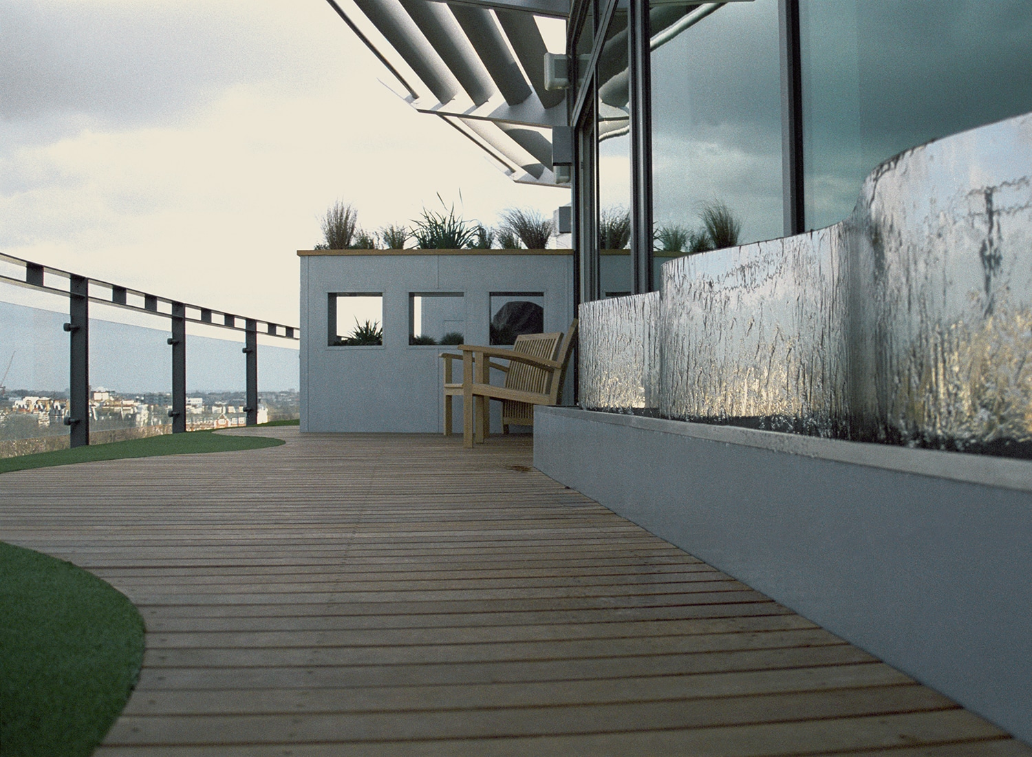 View along the length of the water feature towards the aperture planter and seats