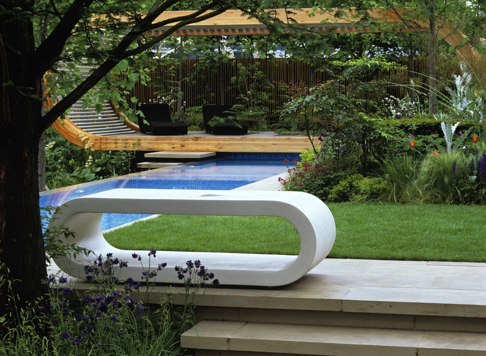 Curved white concrete seat looking towards the pavilion