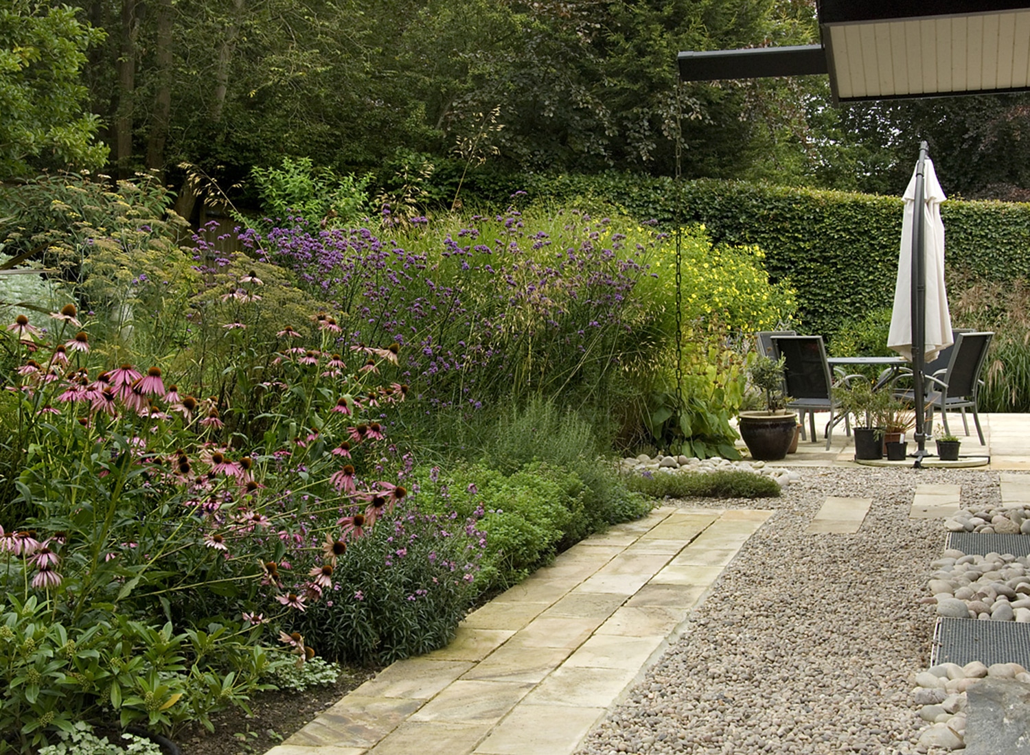 Floral border and patio with table and chairs at the Black Huf House