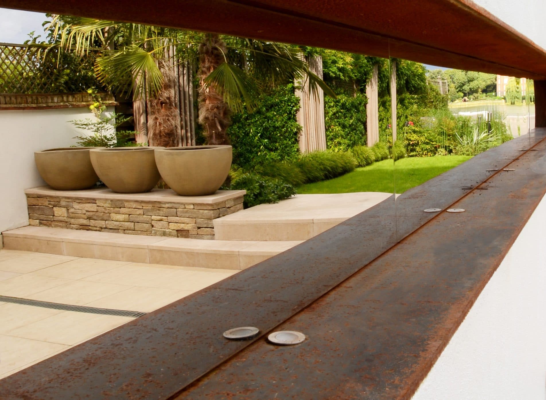 Outdoor mirror reflecting the riverside garden