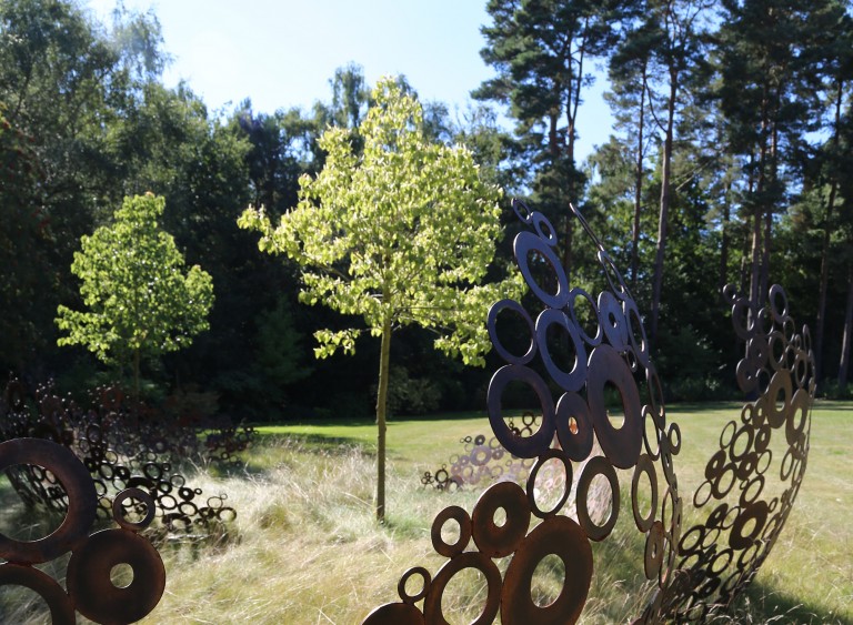 Tree surrounded by sculpture made of metal circles