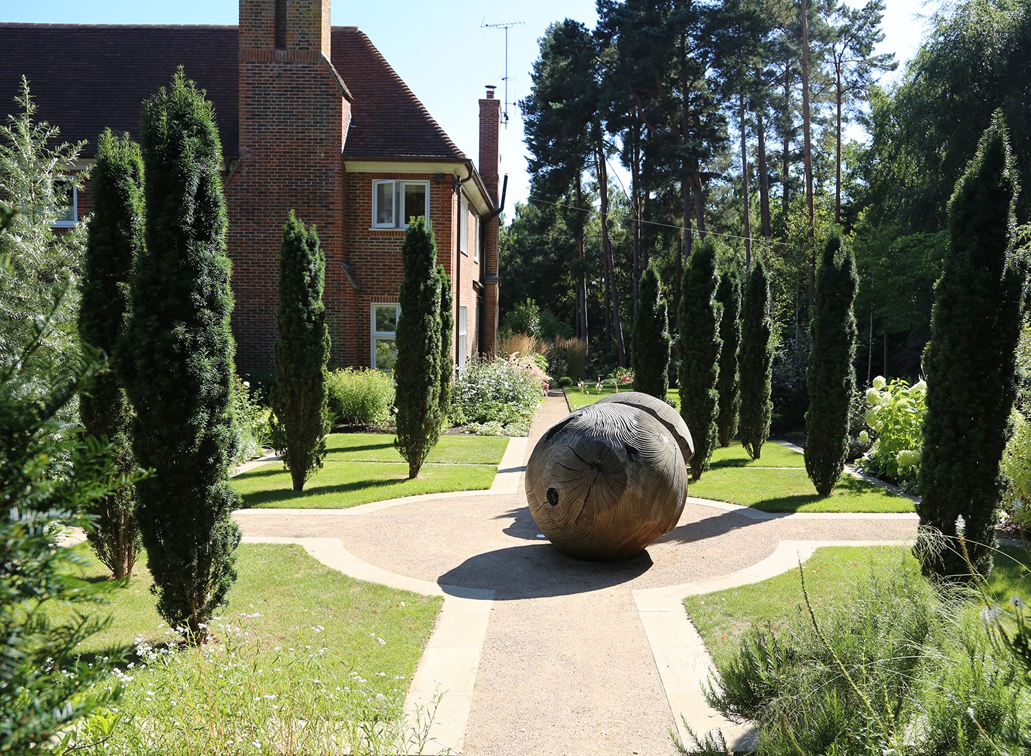 View towards the house across wooden sculptures