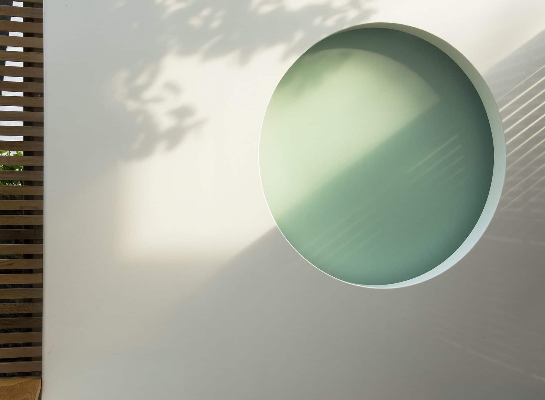 Detail of white rendered wall with moon shaped lighting feature
