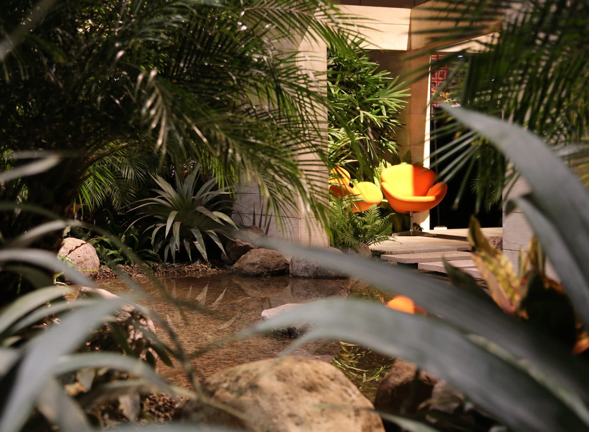 View through plants to two orange seats bathed in sunlight