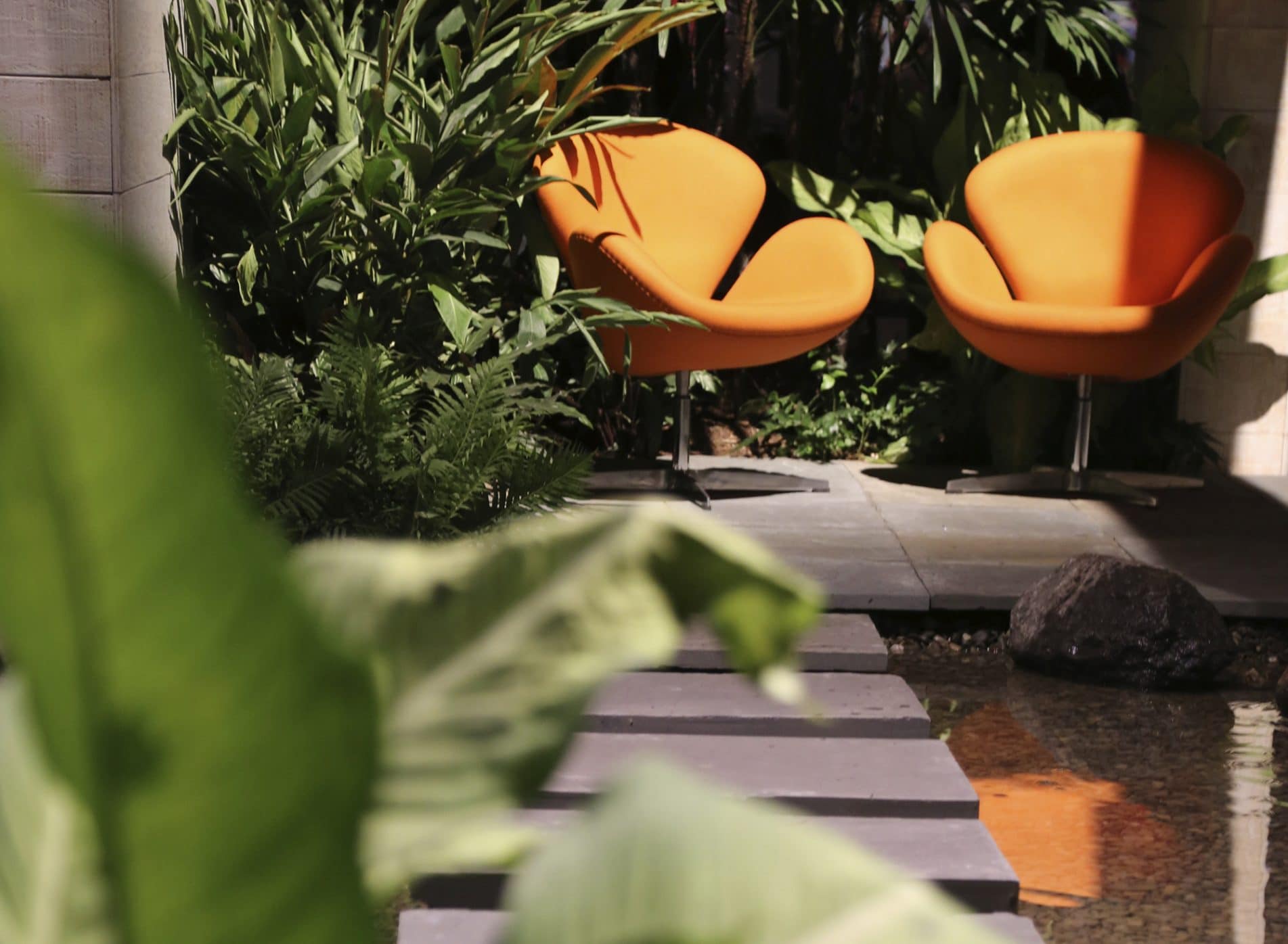 View down a stepping stone path to two orange chairs