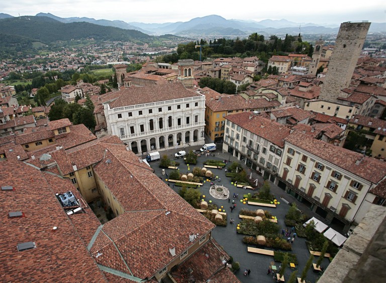 Aerial view of the piazza with the town and hillside beyond