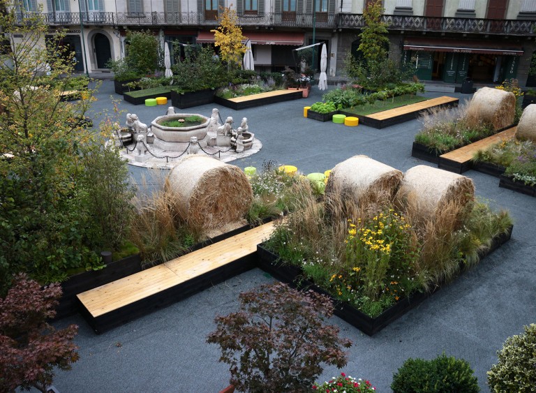 Boxes of planting with haybales, benches and a water feature