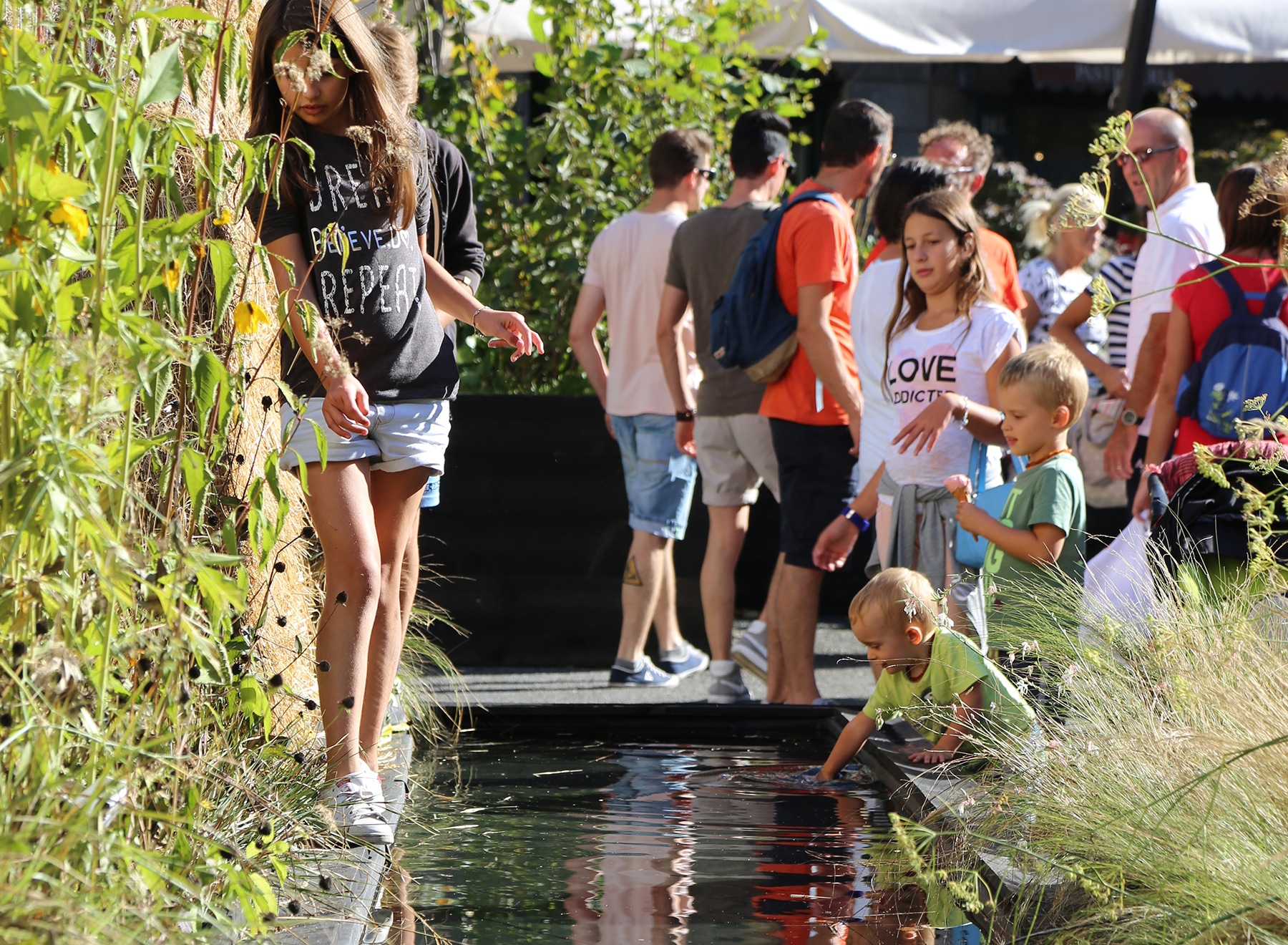 A child puts a hand in the water feature