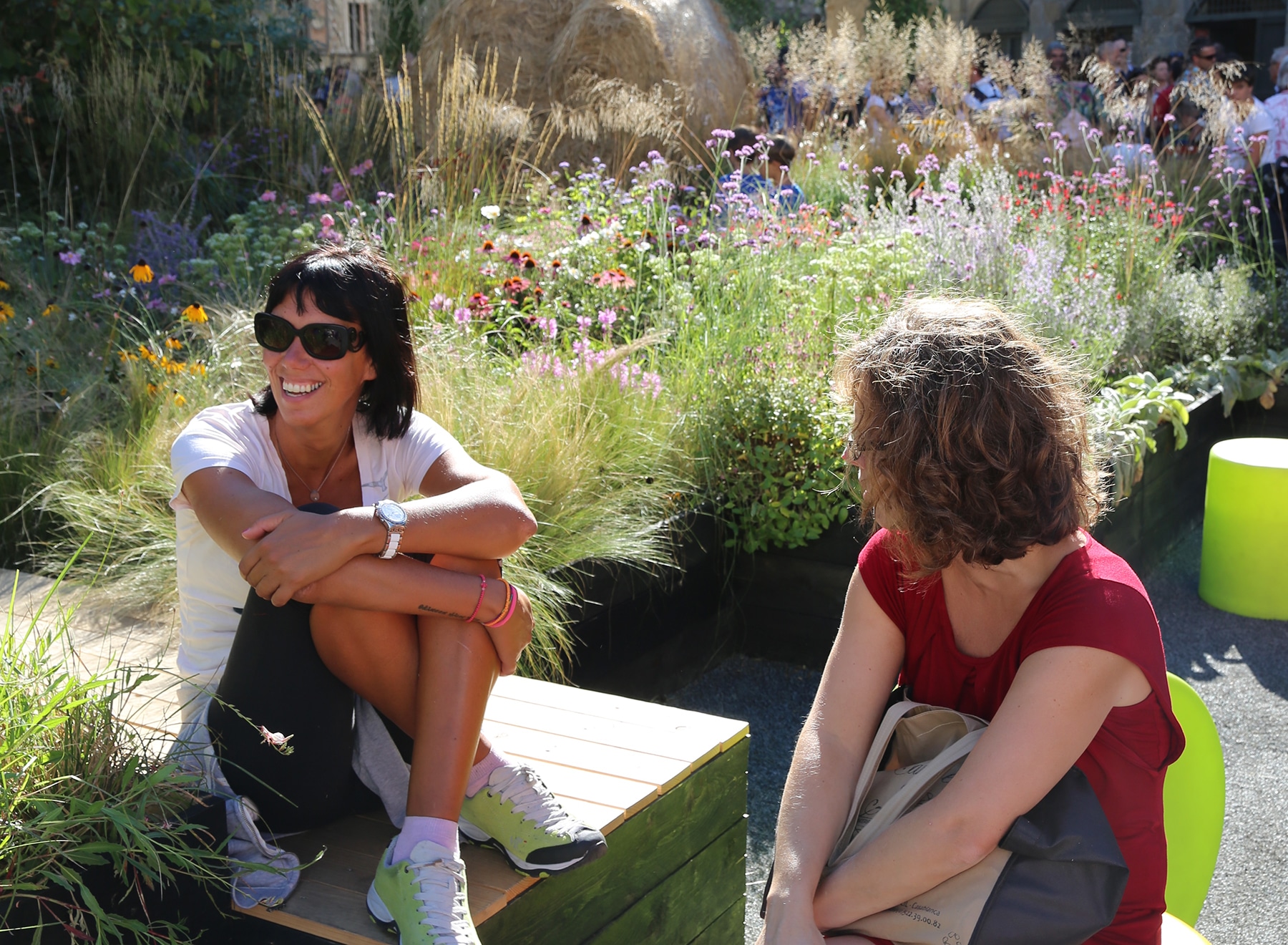 Two ladies relax in the Piazza by the wildflower planting