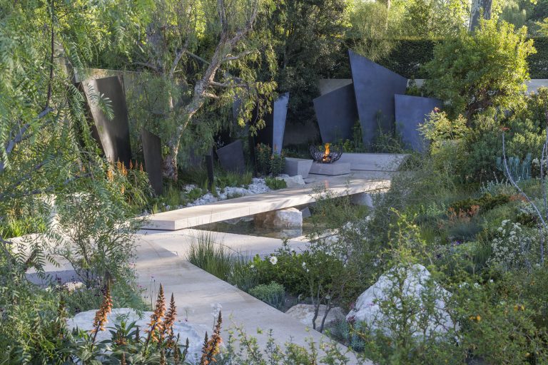 The Telegraph Garden Pathway With Stone Sculptures And Green Shrubs