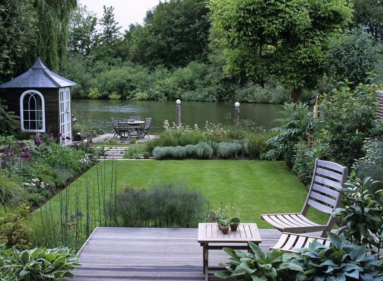 View to the river from the lounge over the deck and lawn with seating by the water