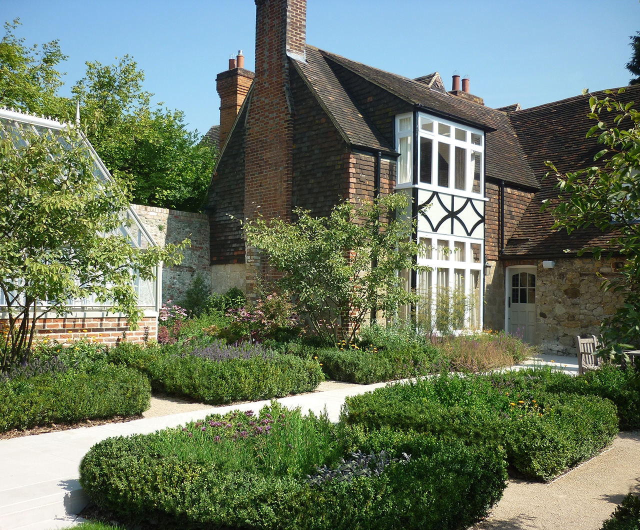 Beautiful House Featuring Path Surrounded By Square Beds Of Green Shrubs And Greenhouse