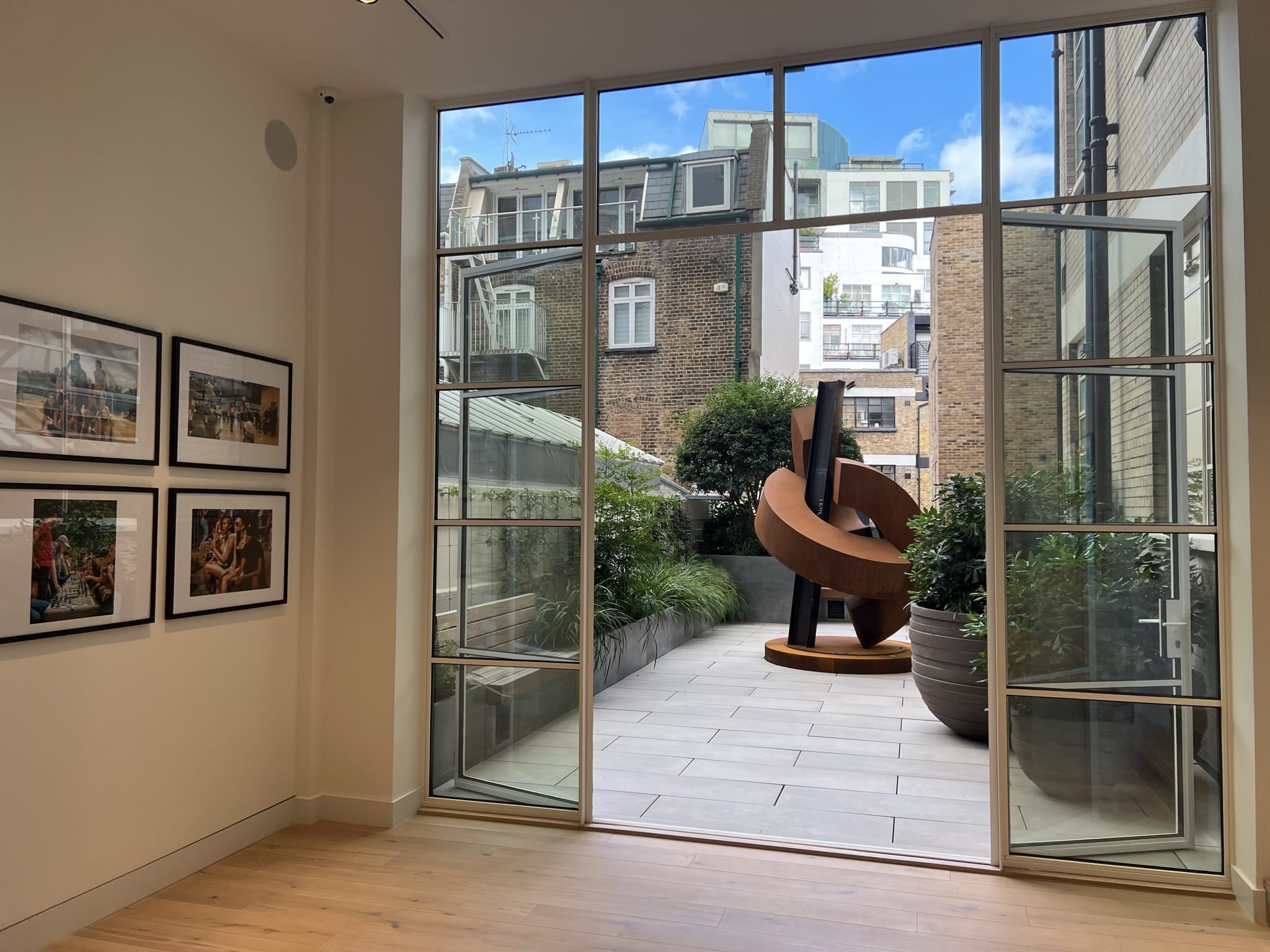 View through a window to a modern sculpture in a roof garden