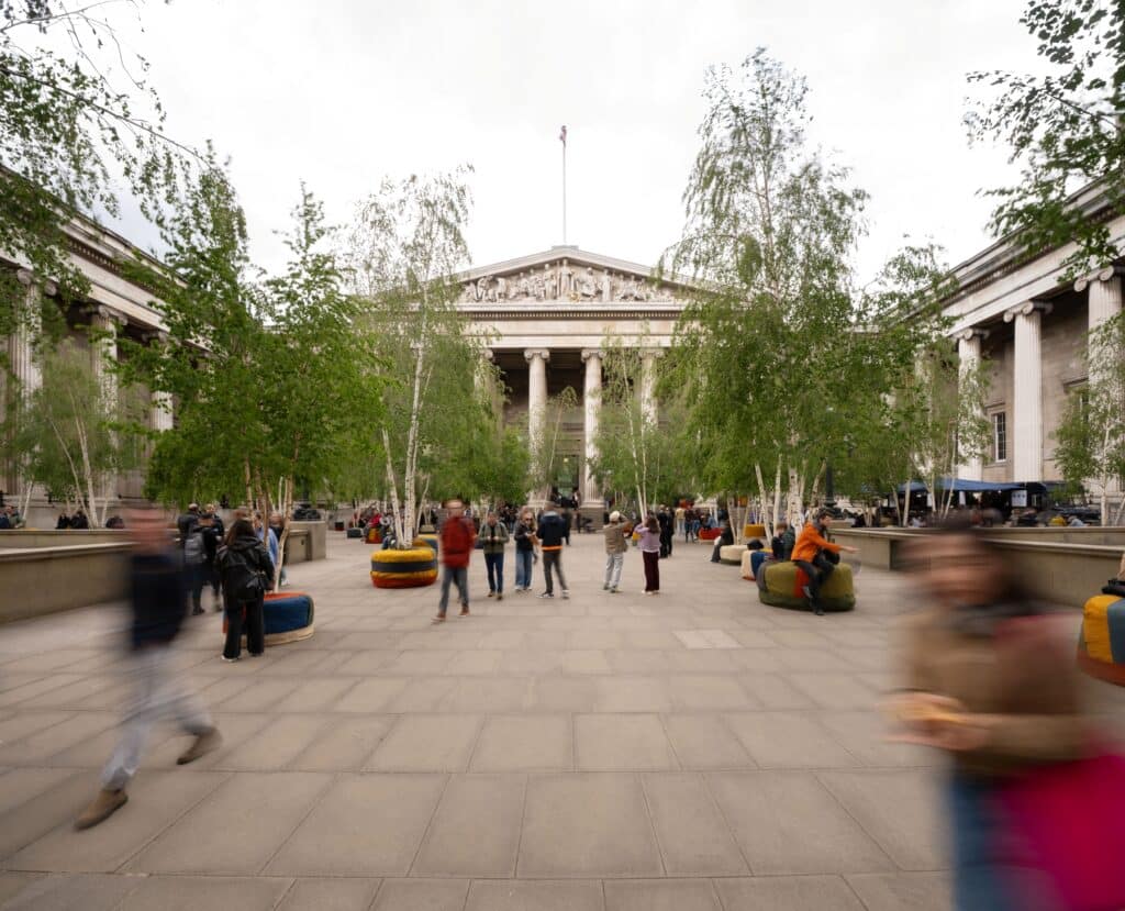 An exhibition a tapestry of trees in the courtyard outside the british museum